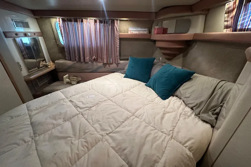 Slide: The Image of Cozy bedroom interior of 1990 Bayliner 4388 Motoryacht with plush bedding and decorative pillows. - 41