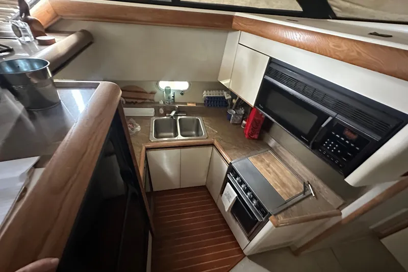 Slide: The Image of 1990 Bayliner 4388 Motoryacht docked under a covered marina. - 9