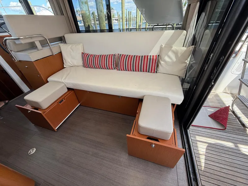 Slide: The Image of Interior of 2016 Beneteau Swift Trawler 30 with white sofa and striped cushions. - 15