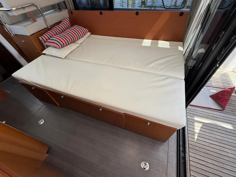 Slide: The Image of Cozy seating area on 2016 Beneteau Swift Trawler 30 with striped cushions and storage. - 16