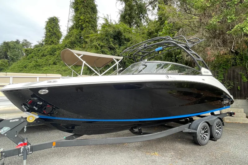 The Image of 2026 Yamaha Boats 252SD on trailer, sleek black design, parked outdoors. - 0