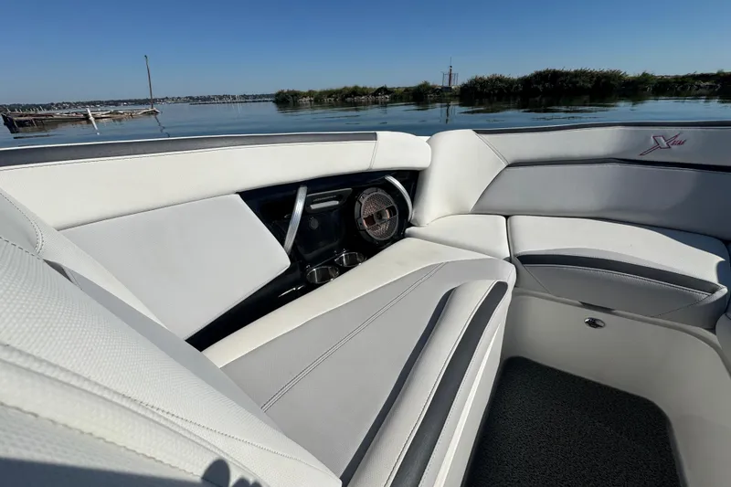 Slide: The Image of 2018 MasterCraft XStar boat interior with sleek white seating and lake view. - 10