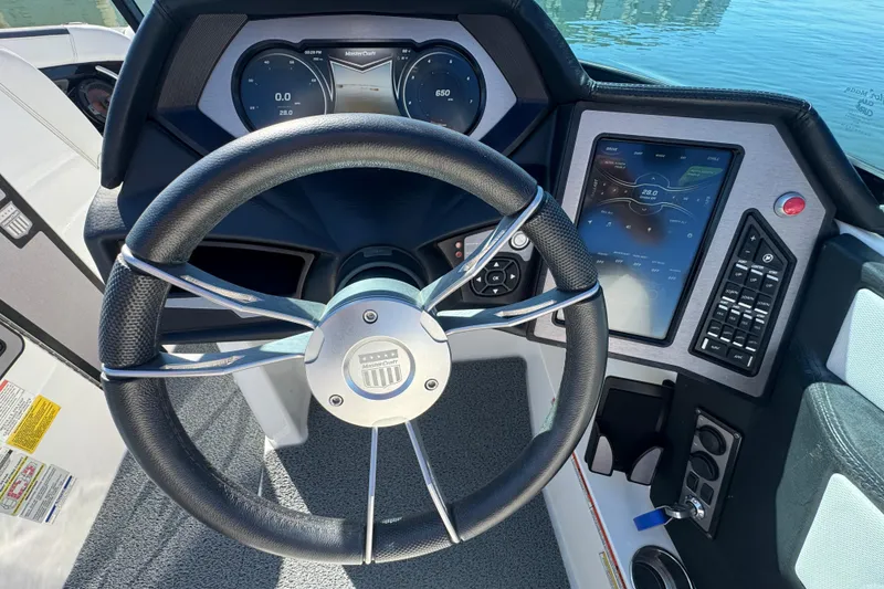Slide: The Image of Steering wheel and dashboard of 2018 MasterCraft XStar boat, featuring digital displays and controls. - 16