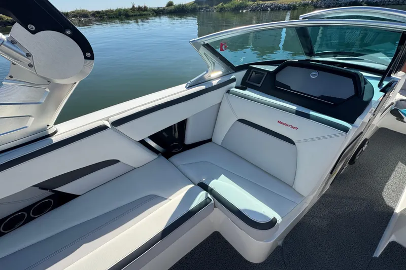 Slide: The Image of 2018 MasterCraft XStar boat interior with sleek seating and modern design on calm water. - 19