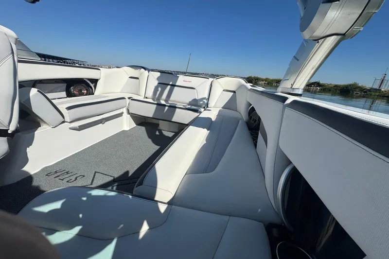 Slide: The Image of 2018 MasterCraft XStar boat interior with white seating and lake view. - 20