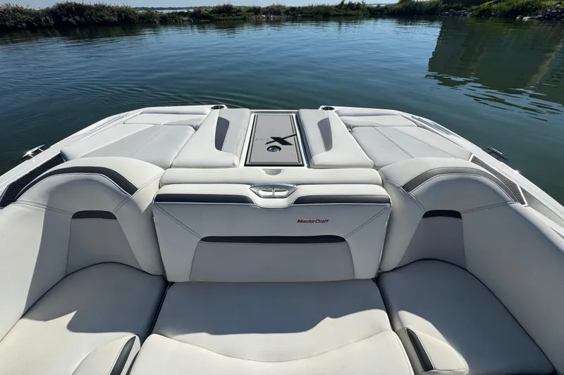 Slide: The Image of 2018 MasterCraft XStar boat interior with luxurious seating on calm water. - 22