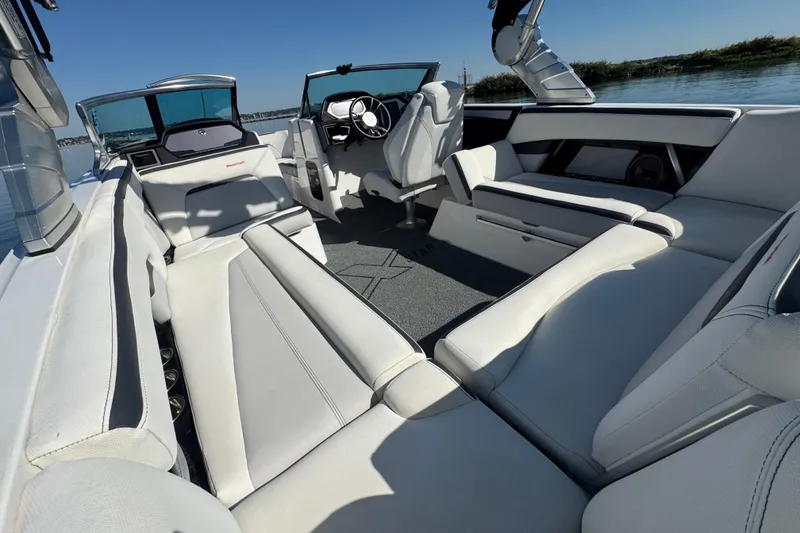Slide: The Image of 2018 MasterCraft XStar boat interior with luxurious white seating and modern dashboard. - 24