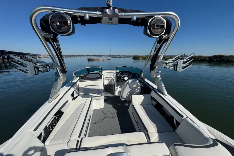 Slide: The Image of 2018 MasterCraft XStar boat interior with wakeboard tower on calm water. - 26