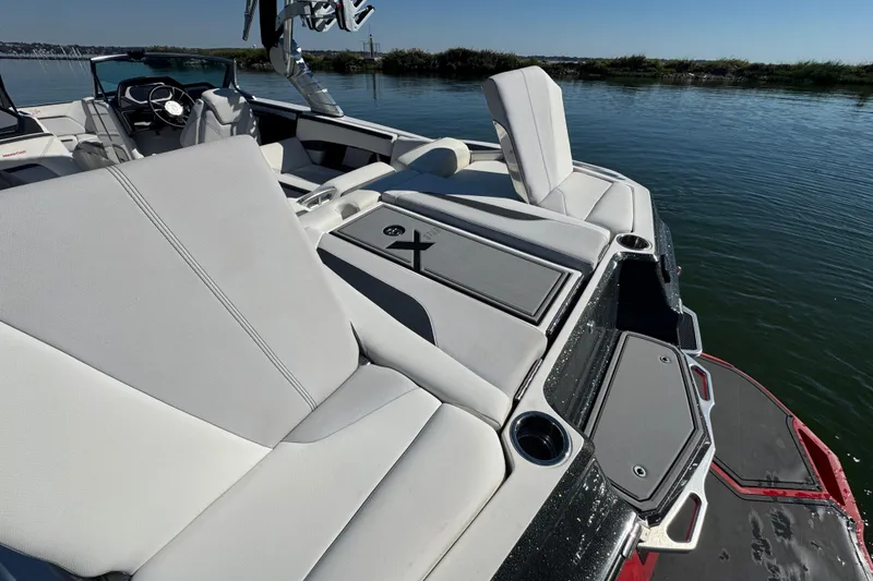 Slide: The Image of 2018 MasterCraft XStar boat with luxurious seating on a calm lake. - 27
