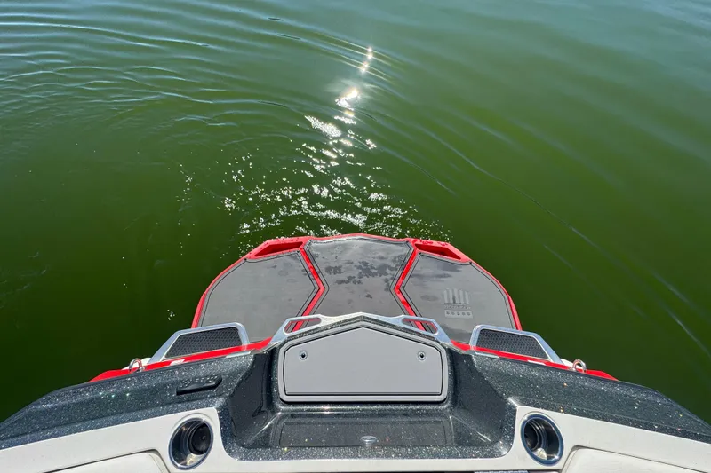 Slide: The Image of 2018 MasterCraft XStar boat platform on calm green water, sunlight reflecting. - 28