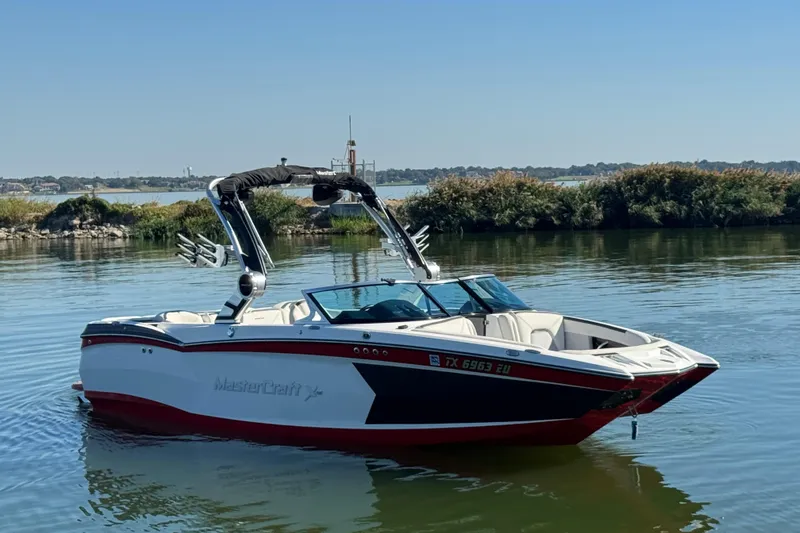 Slide: The Image of 2018 MasterCraft XStar boat on calm lake with scenic background. - 3