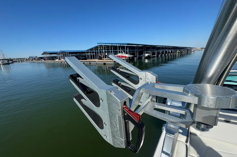 Slide: The Image of 2018 MasterCraft XStar boat with wakeboard rack, docked at marina under clear blue sky. - 32