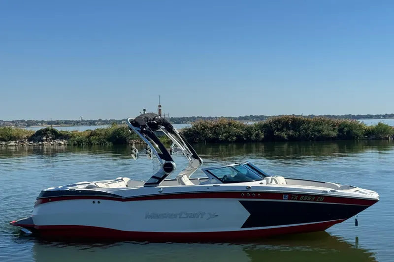 Slide: The Image of 2018 MasterCraft XStar boat on calm lake with clear blue sky. - 4