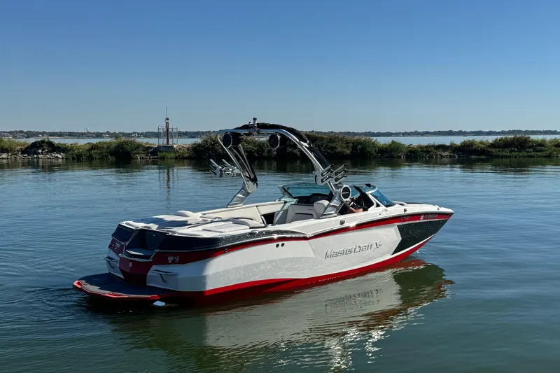 Slide: The Image of 2018 MasterCraft XStar boat on calm water, clear sky background. - 6