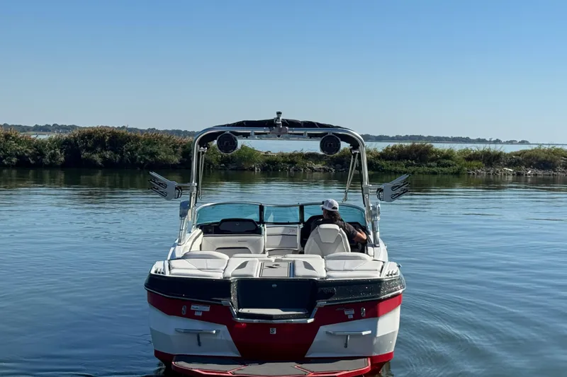 Slide: The Image of 2018 MasterCraft XStar boat on calm water with scenic background. - 7
