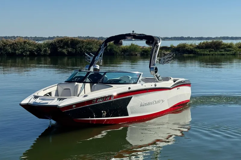 Slide: The Image of 2018 MasterCraft XStar boat on calm lake waters, featuring sleek design and vibrant colors. - 8