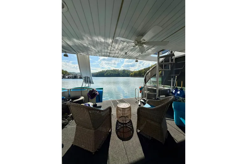 Slide: The Image of Cozy houseboat deck with wicker chairs, overlooking serene lake and lush greenery. - 21