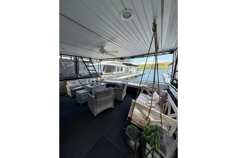 Slide: The Image of Spacious 2001 Fantasy houseboat deck with cozy seating, swing, and scenic waterfront view. - 22