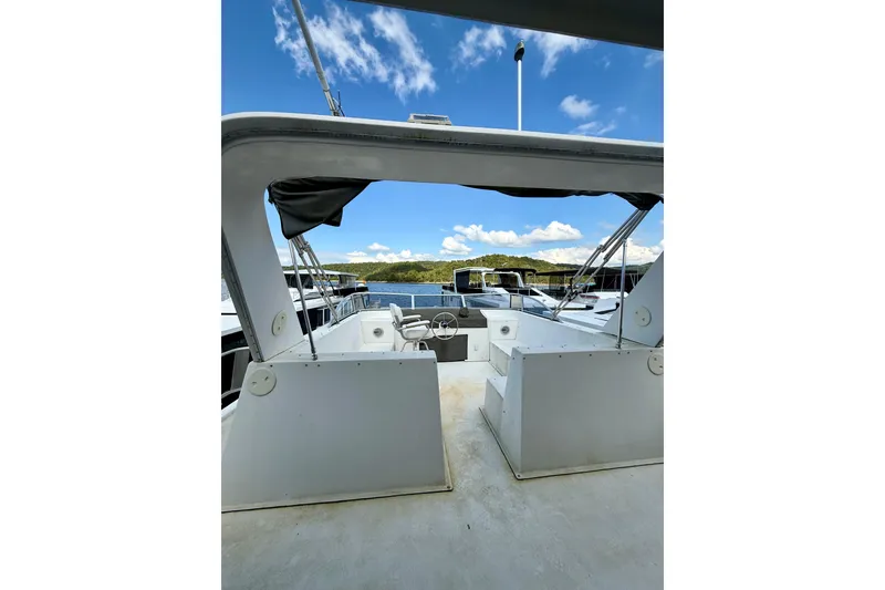 Slide: The Image of 2001 Fantasy houseboat deck with steering wheel, under clear blue sky. - 24
