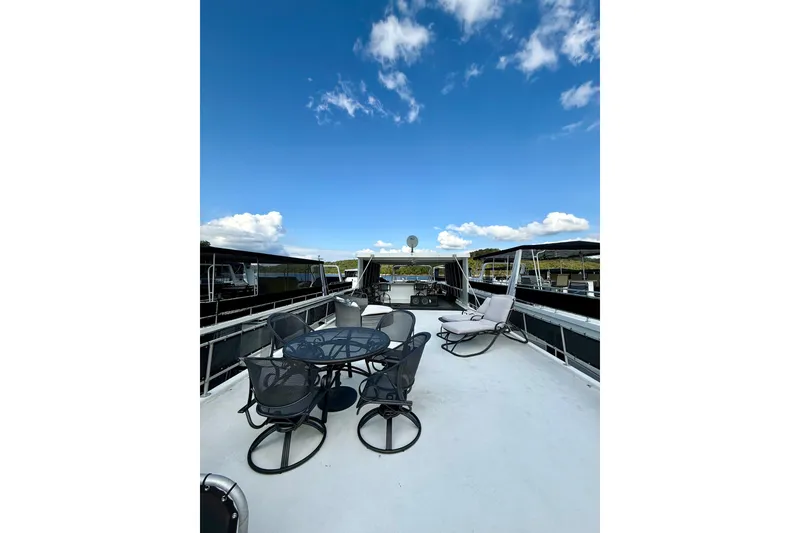 Slide: The Image of Rooftop deck of 2001 Fantasy houseboat with seating, under a clear blue sky. - 25