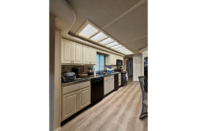 Slide: The Image of Spacious kitchen in 2001 Fantasy houseboat with modern appliances and wooden flooring. - 8