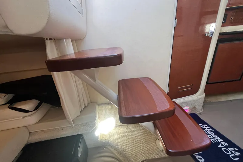 Slide: The Image of Interior stairs of a 2002 Sea Ray 300 Sundancer yacht with wooden steps. - 12
