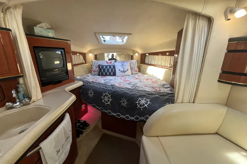 Slide: The Image of 2002 Sea Ray 300 Sundancer cabin interior with bed, TV, and sink. Cozy and well-equipped. - 15