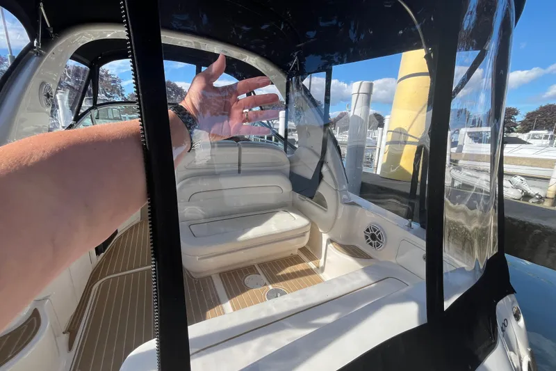 Slide: The Image of 2002 Sea Ray 300 Sundancer cockpit with clear enclosure and seating, docked at marina. - 3