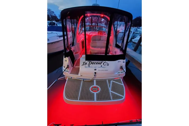 Slide: The Image of 2002 Sea Ray 300 Sundancer with red deck lighting at a marina. - 4
