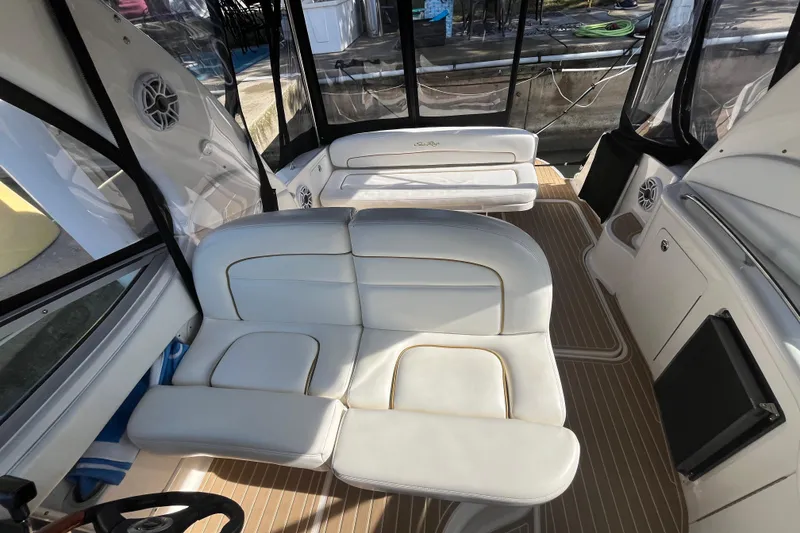 Slide: The Image of 2002 Sea Ray 300 Sundancer interior with white seating and wood-patterned flooring. - 9