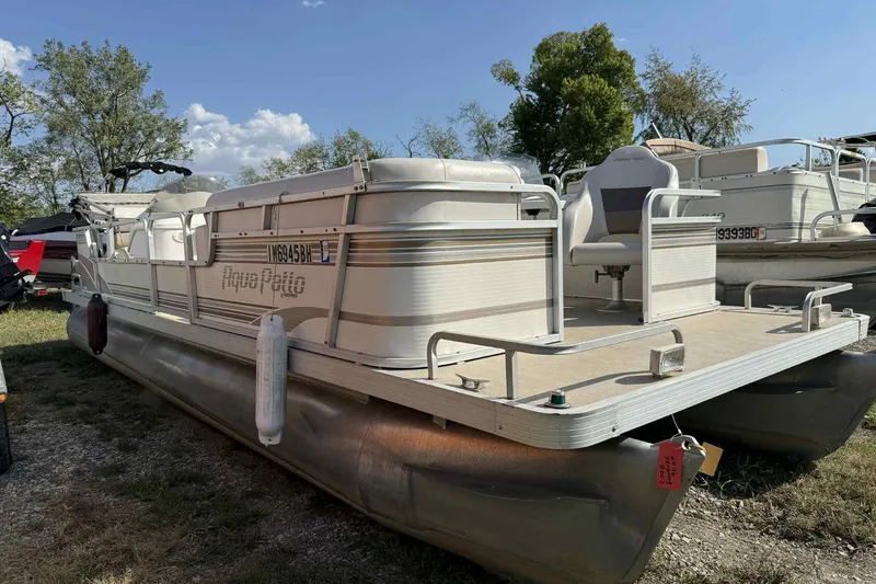 The Image of 2001 AquaPatio 240 RS pontoon boat parked on grass under a clear blue sky. - 0