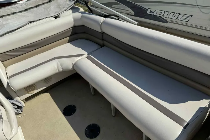 Slide: The Image of Interior seating of 2001 AquaPatio 240 RS boat, featuring beige and gray upholstery. - 10