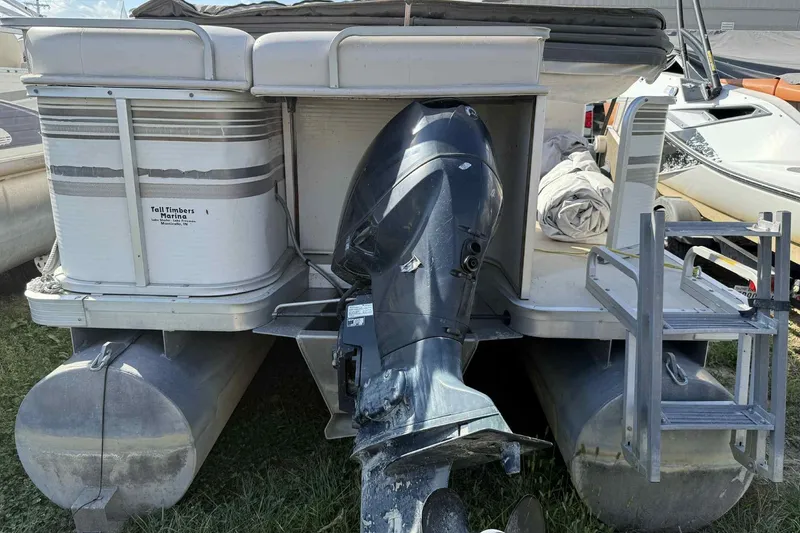 Slide: The Image of 2001 AquaPatio 240 RS pontoon boat with outboard motor and ladder, parked on grass. - 4