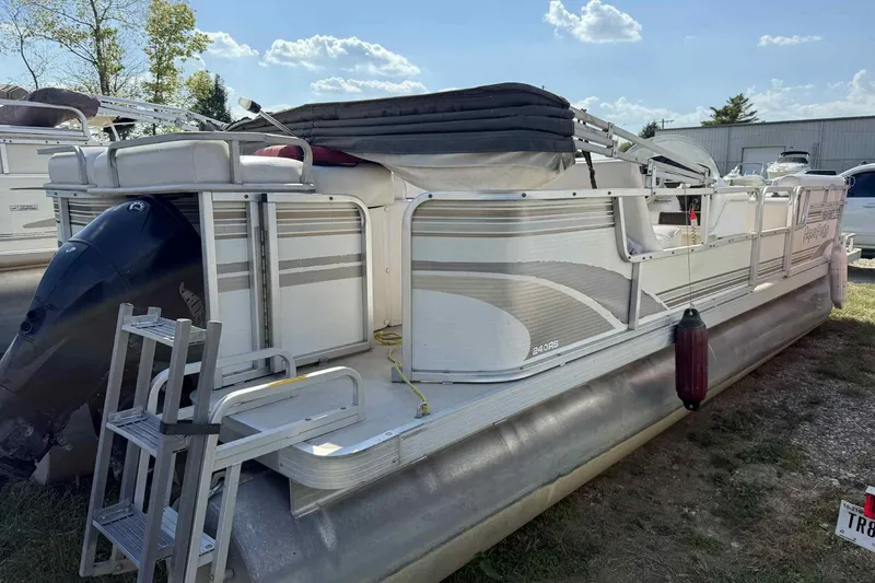 Slide: The Image of 2001 AquaPatio 240 RS pontoon boat with outboard motor and ladder, parked outdoors. - 5