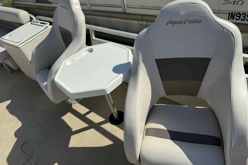 Slide: The Image of AquaPatio 240 RS 2001 boat seats with table, featuring gray upholstery. - 8