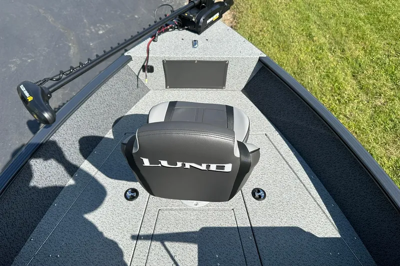 Slide: The Image of 2026 Lund 1775 Adventure Sport boat, rear view with motor and ladder, parked outdoors. - 5