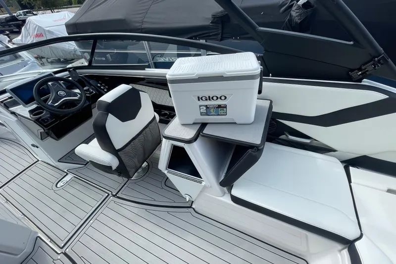 Slide: The Image of 2026 Yamaha Boats 252SD interior with Igloo cooler on table, featuring sleek seating and steering wheel. - 16