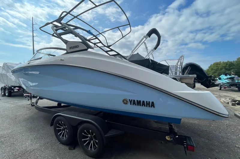 Slide: The Image of 2026 Yamaha Boats 252SD on trailer, sleek design, blue and white exterior, under clear sky. - 3