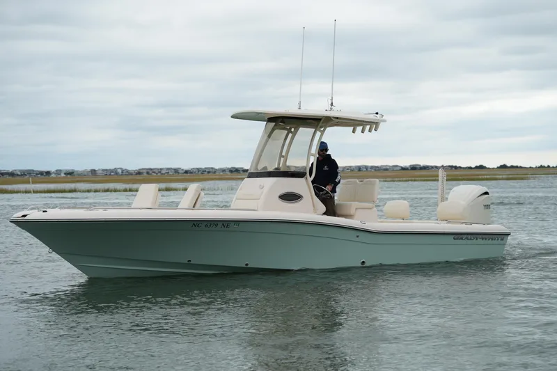Slide: The Image of 2025 Grady-White 251 Coastal Explorer boat cruising on calm waters under cloudy skies. - 15
