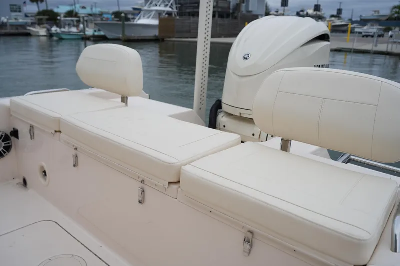 Slide: The Image of 2025 Grady-White 251 Coastal Explorer boat interior with cushioned seating and outboard motor. - 17