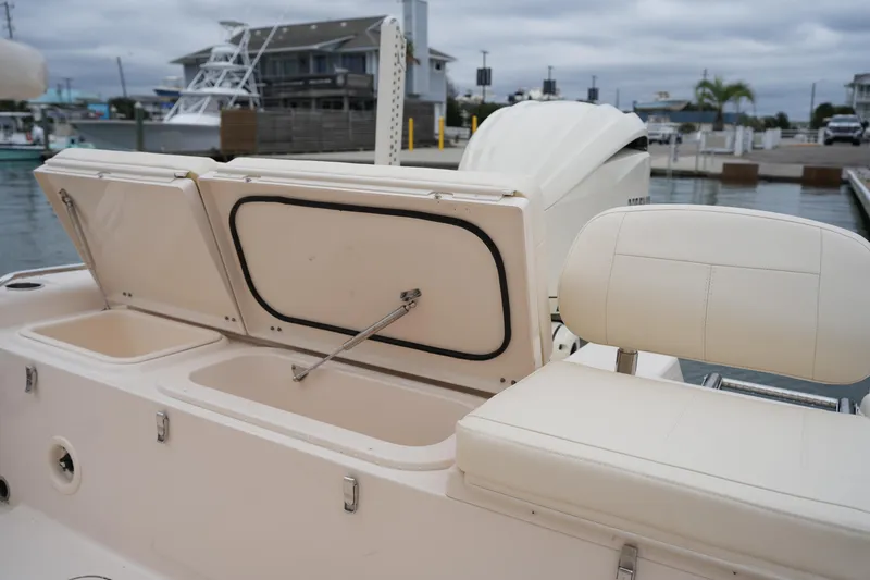Slide: The Image of 2025 Grady-White 251 Coastal Explorer boat with open storage compartments at a marina. - 18