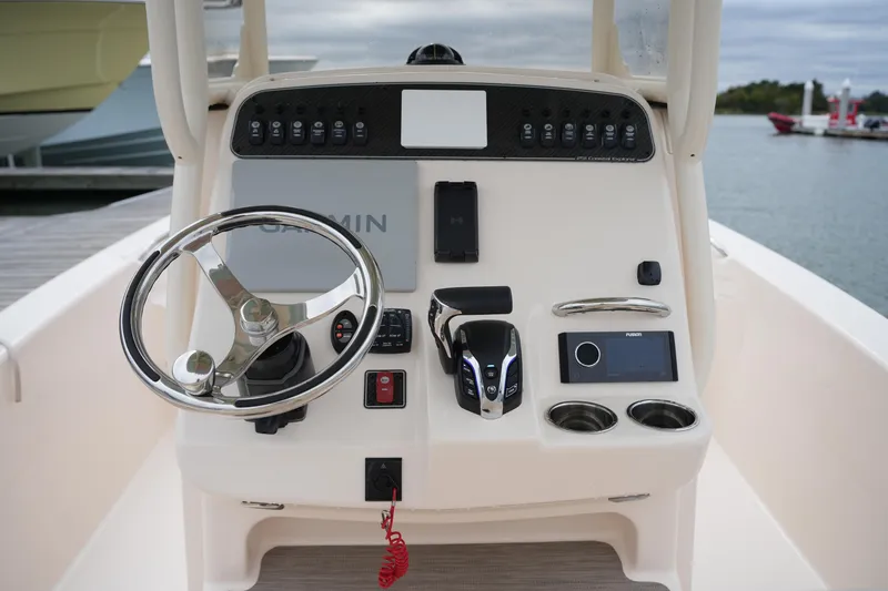 Slide: The Image of 2025 Grady-White 251 Coastal Explorer boat dashboard with steering wheel and controls. - 25