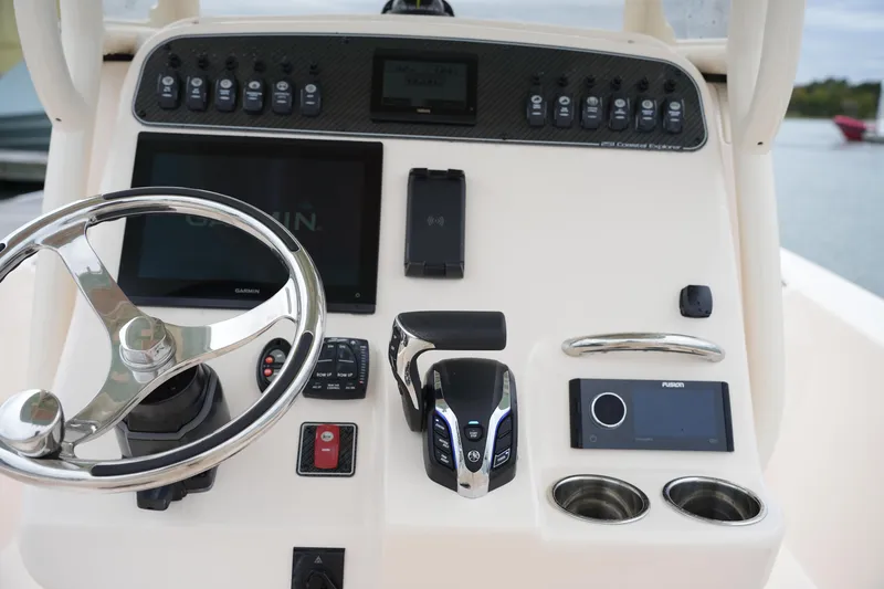 Slide: The Image of 2025 Grady-White 251 Coastal Explorer boat dashboard with steering wheel and electronic controls. - 27