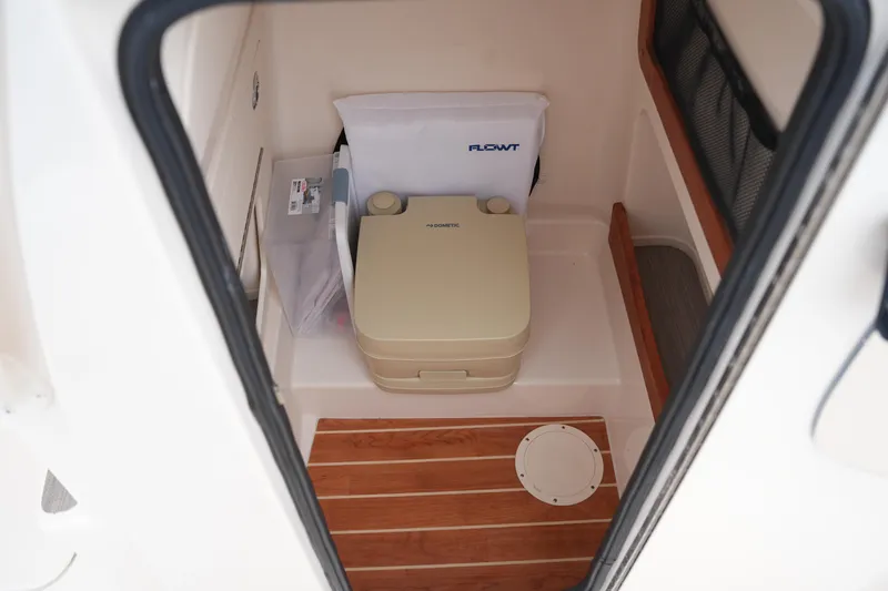 Slide: The Image of 2025 Grady-White 251 Coastal Explorer interior with portable toilet and storage. - 34