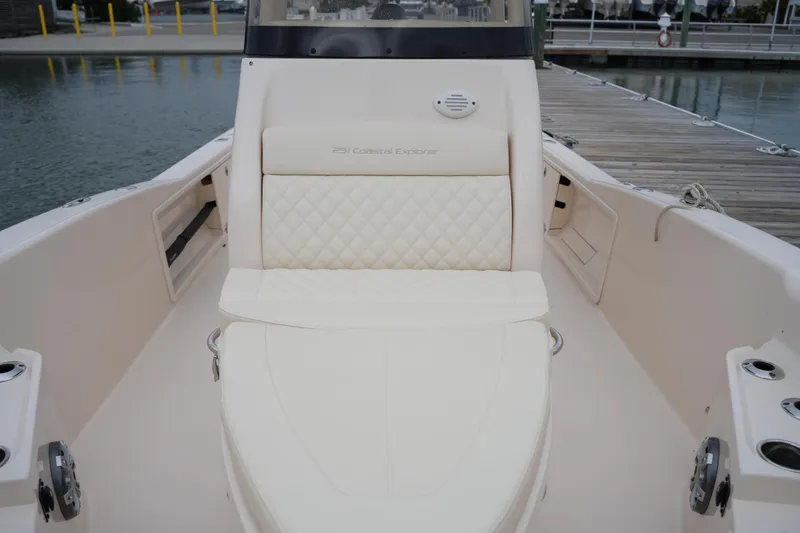 Slide: The Image of 2025 Grady-White 251 Coastal Explorer boat interior with cushioned seating at dock. - 35