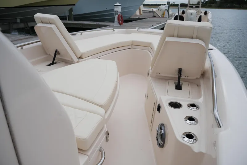 Slide: The Image of 2025 Grady-White 251 Coastal Explorer boat interior with cushioned seating and cup holders. - 37