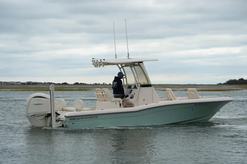 Slide: The Image of 2025 Grady-White 251 Coastal Explorer boat cruising on calm waters under cloudy skies. - 6