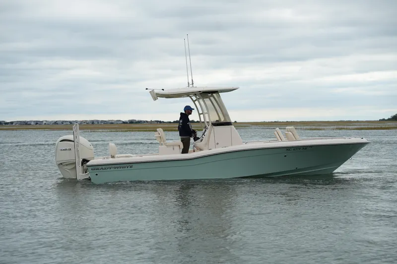Slide: The Image of 2025 Grady-White 251 Coastal Explorer boat cruising on calm waters under cloudy skies. - 7