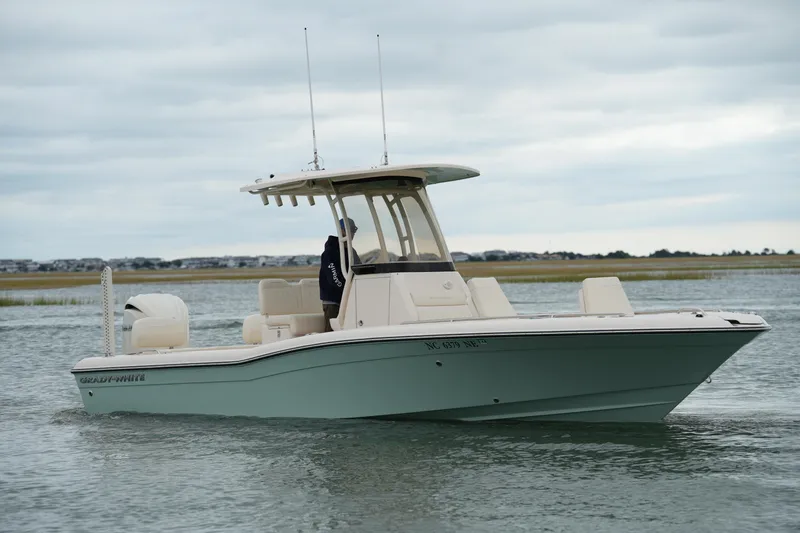 Slide: The Image of 2025 Grady-White 251 Coastal Explorer boat on calm water under cloudy sky. - 8