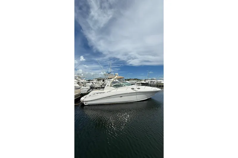 The Image of 2006 Sea Ray 340 Sundancer yacht docked at marina under blue sky. - 0